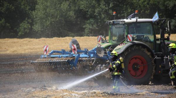 Um dem Feuer den Weg abzuschneiden, gruben Landwirte mithilfe ihrer Landmaschinen zudem den Boden rund um den brennenden Feldabschnitt um.