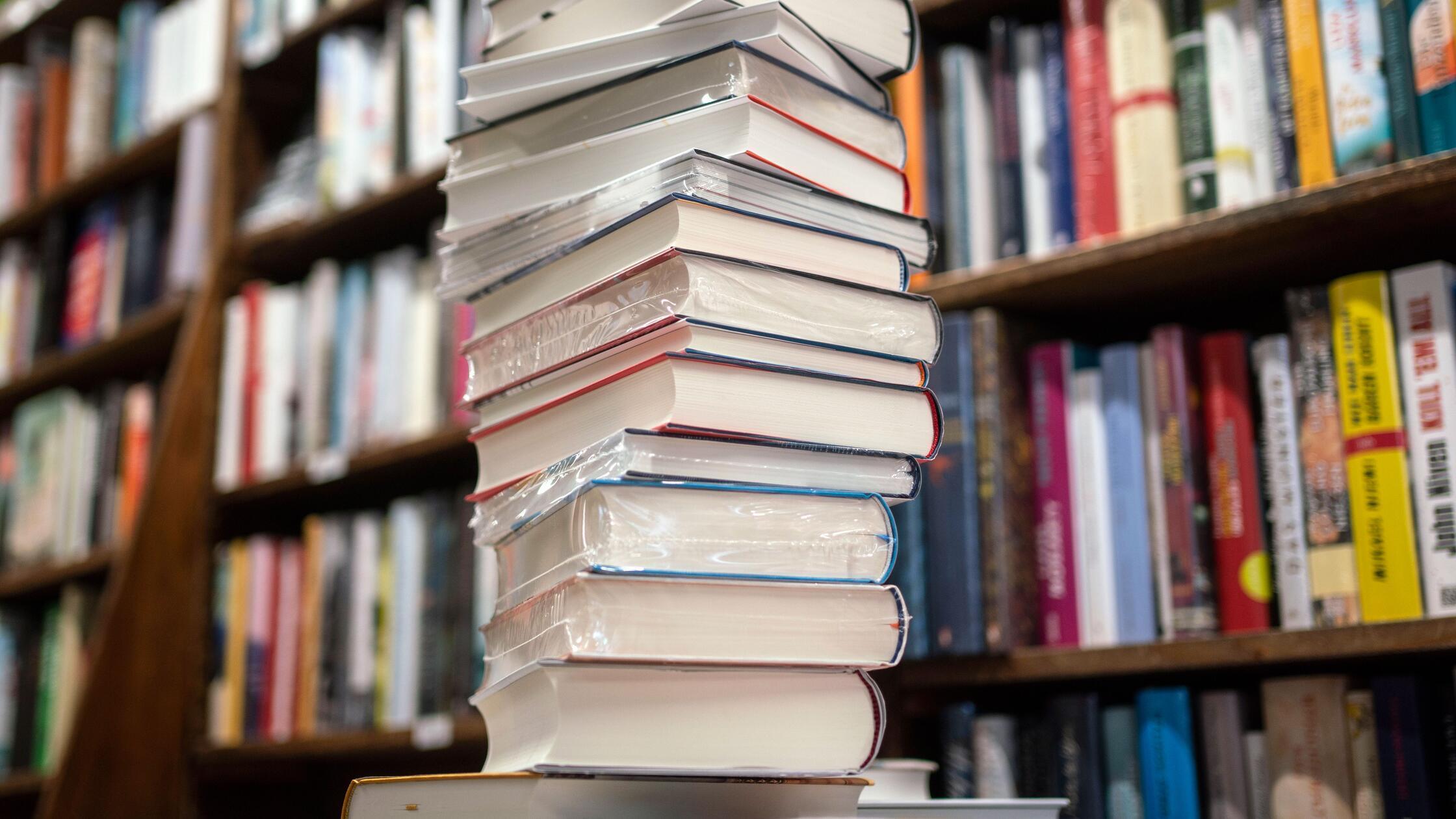 ILLUSTRATION - Ein Stapel neuer Bücher liegt auf e