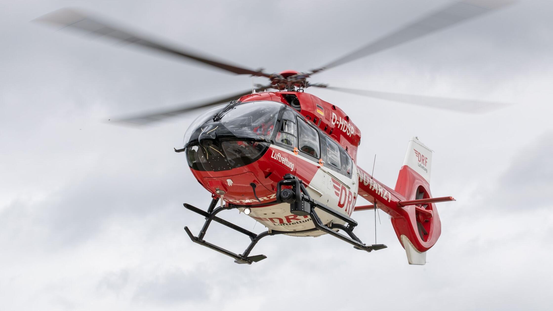 Ein Rettungshubschrauber fliegt einen Einsatz. (zu