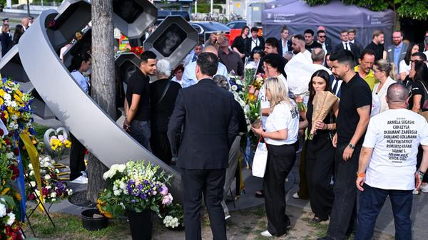 Angehörige der Opfer stehen beim Gedenkakt der Lan