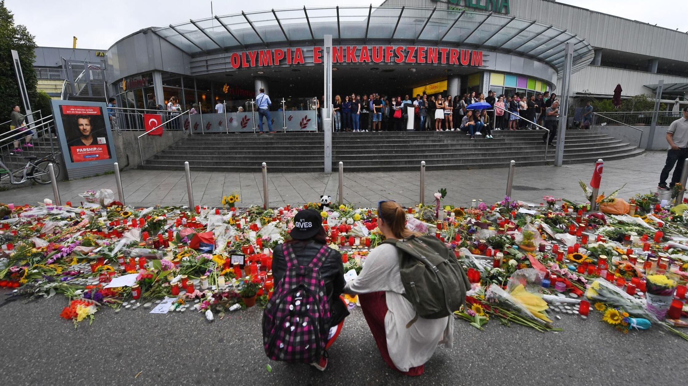 Blumen und Kerzen liegen vor dem Haupteingang des 