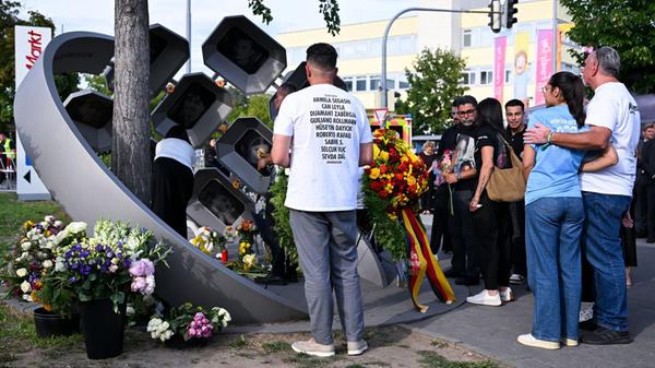 Angehörige der Opfer stehen beim Gedenkakt der Lan