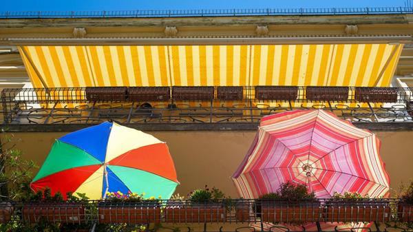 30.06.2026, Berlin: Zwei bunte Sonnenschirme stehe