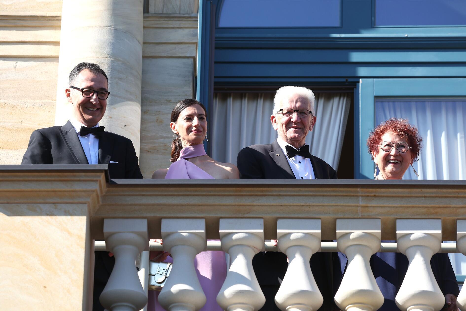 Baden-Württembergs Ministerpräsident Cem Özdemir mit seiner Frau Flavia Zaka sowie der ehemalige Ministerpräsident Winfried Kretschmann mit seiner Frau Gerlinde Kretschmann genießen den Blick vom Balkon des Festspielhauses.