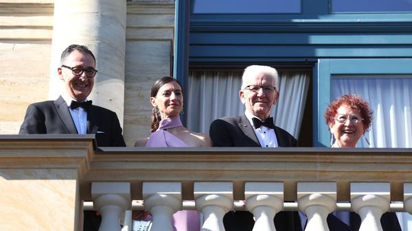 Baden-Württembergs Ministerpräsident Cem Özdemir mit seiner Frau Flavia Zaka sowie der ehemalige Ministerpräsident Winfried Kretschmann mit seiner Frau Gerlinde Kretschmann genießen den Blick vom Balkon des Festspielhauses.