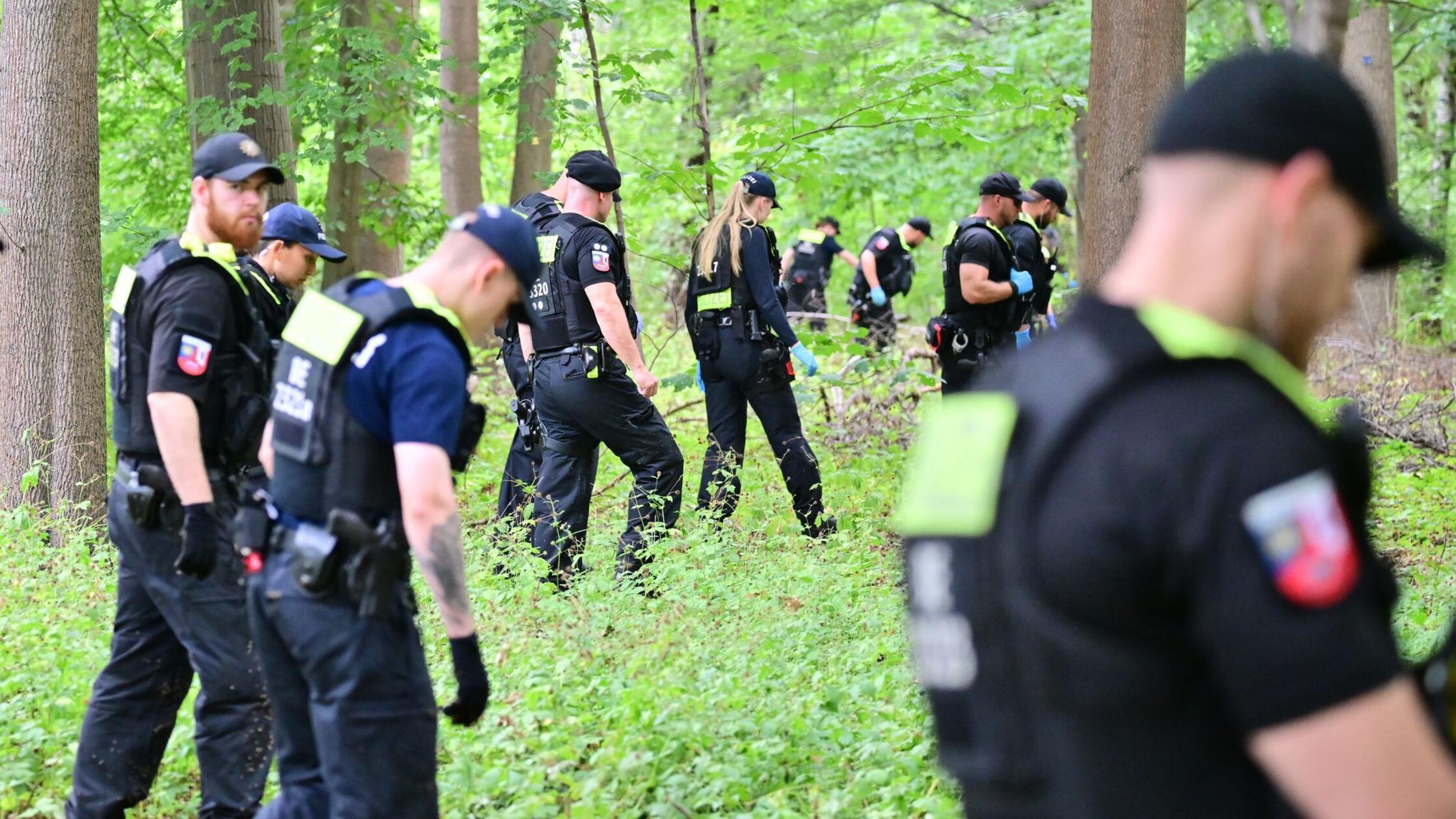 Einsatzkräfte der Polizei durchsuchen den Forst in