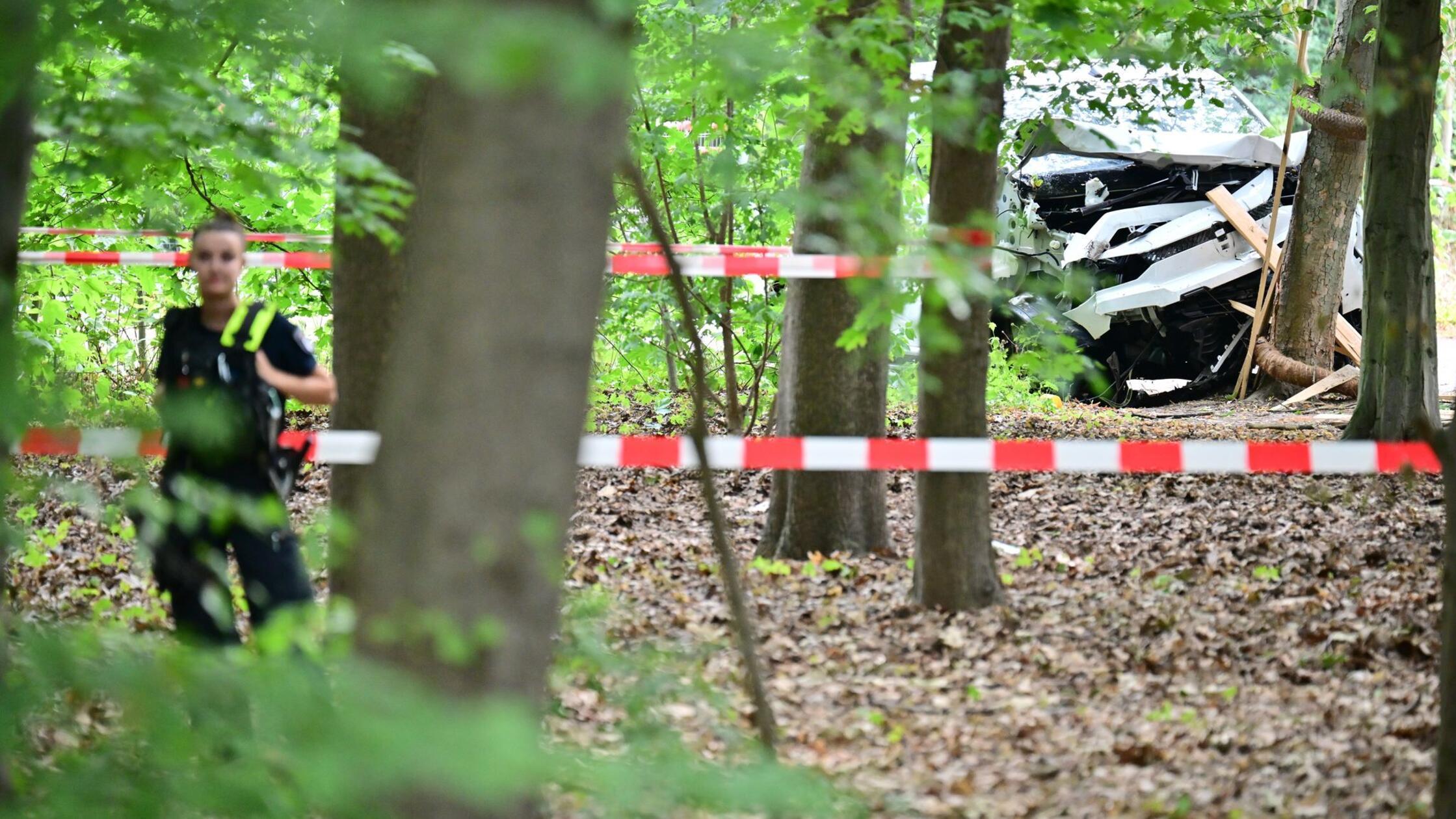 Eine Polizeibeamtin steht zwischen den Bäumen im B