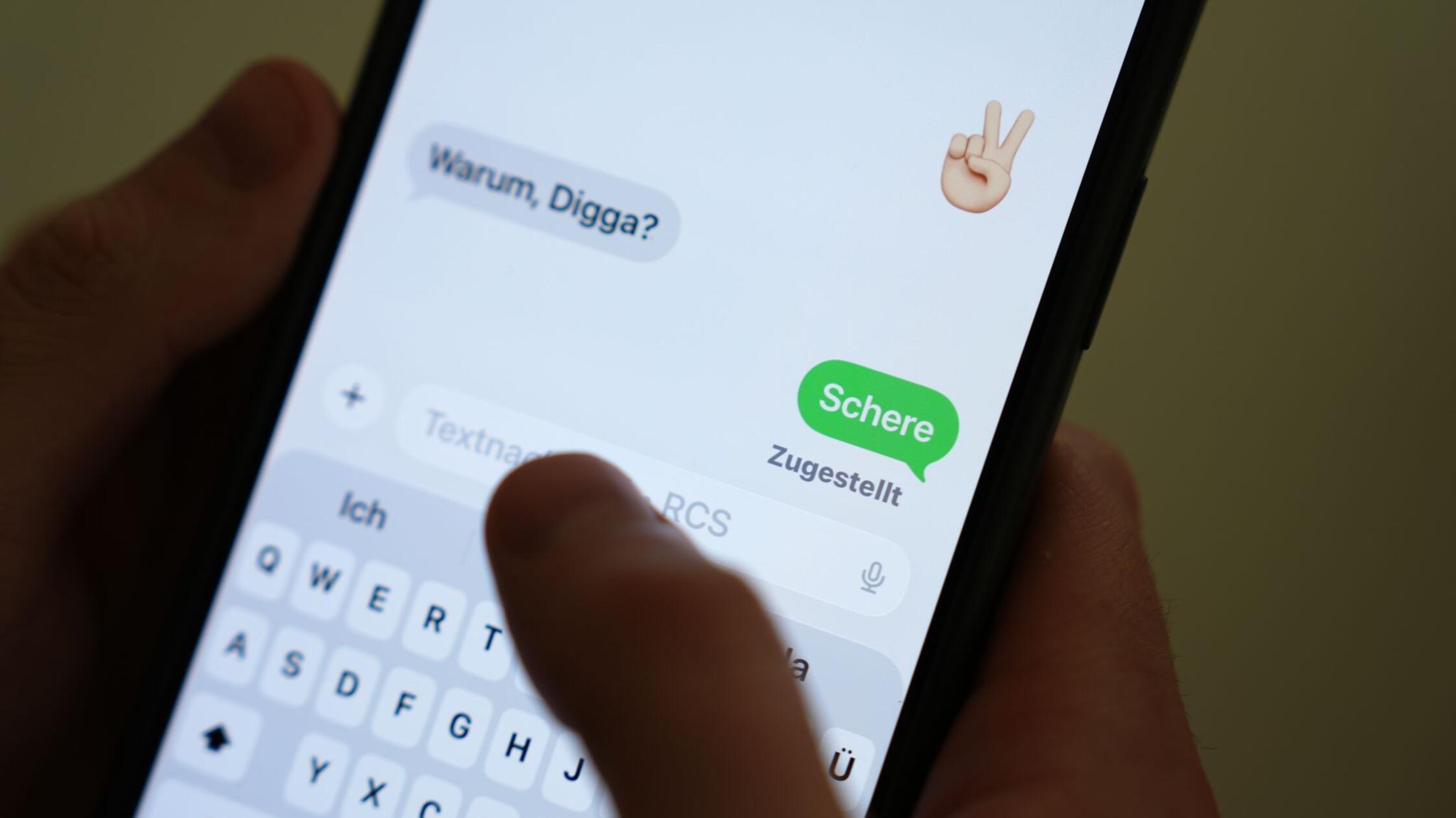 Das Wort „Schere“ ist auf dem Display eines Smartp