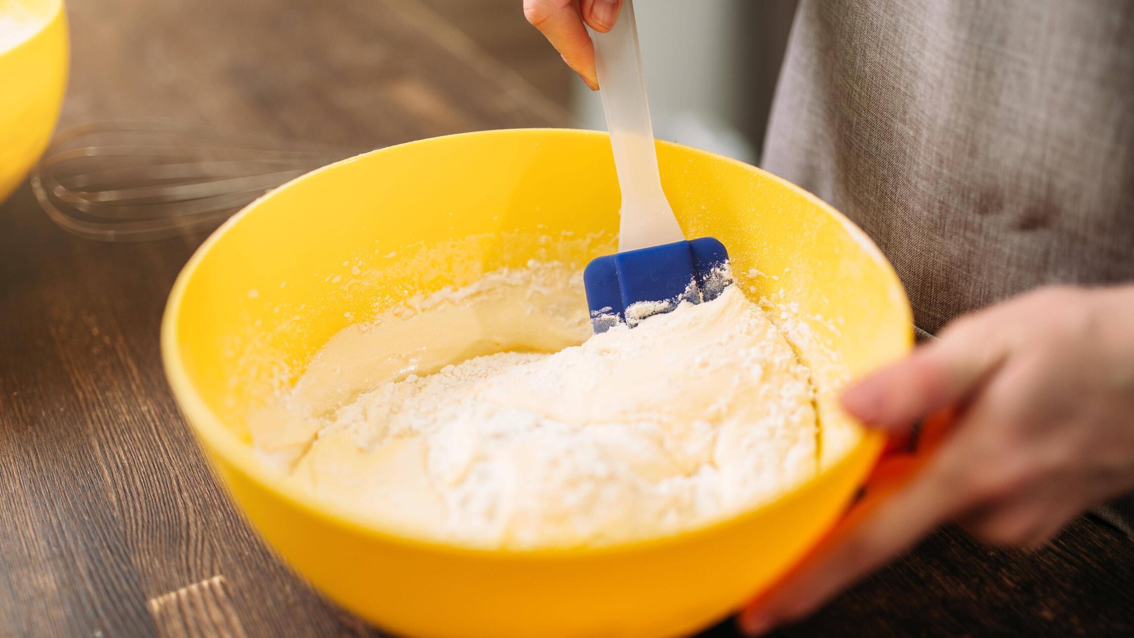 Woman in apron stir the dough on wooden table Copy