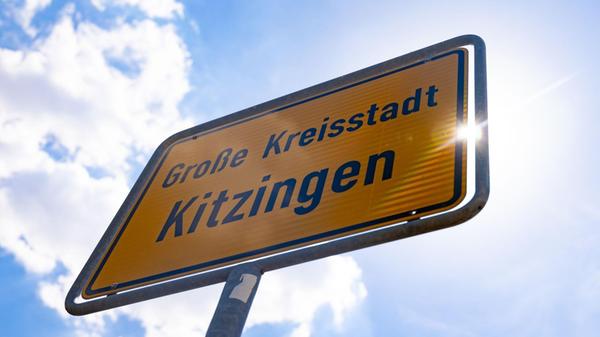 Die Sonne scheint hinter dem Ortsschild von Kitzin