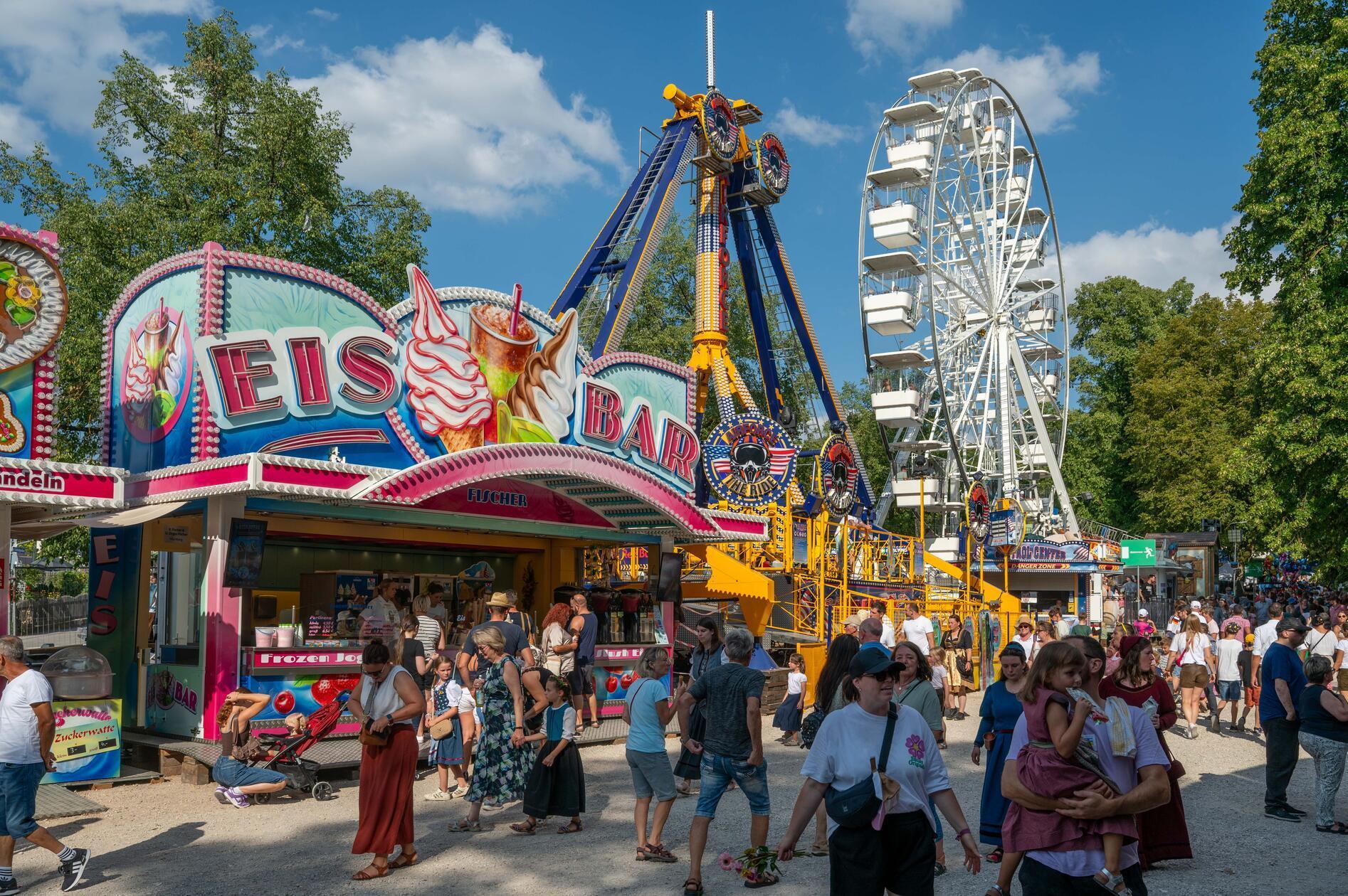 Zwischen Autoscooter, Kettenkarussell und Riesenrad ist am Nachmittag schon einiges los: Die Eisbar auf dem Festplatz zieht bei sommerlichen Temperaturen viele Besucher an.