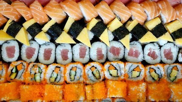 A colorful assortment of various sushi and maki, i