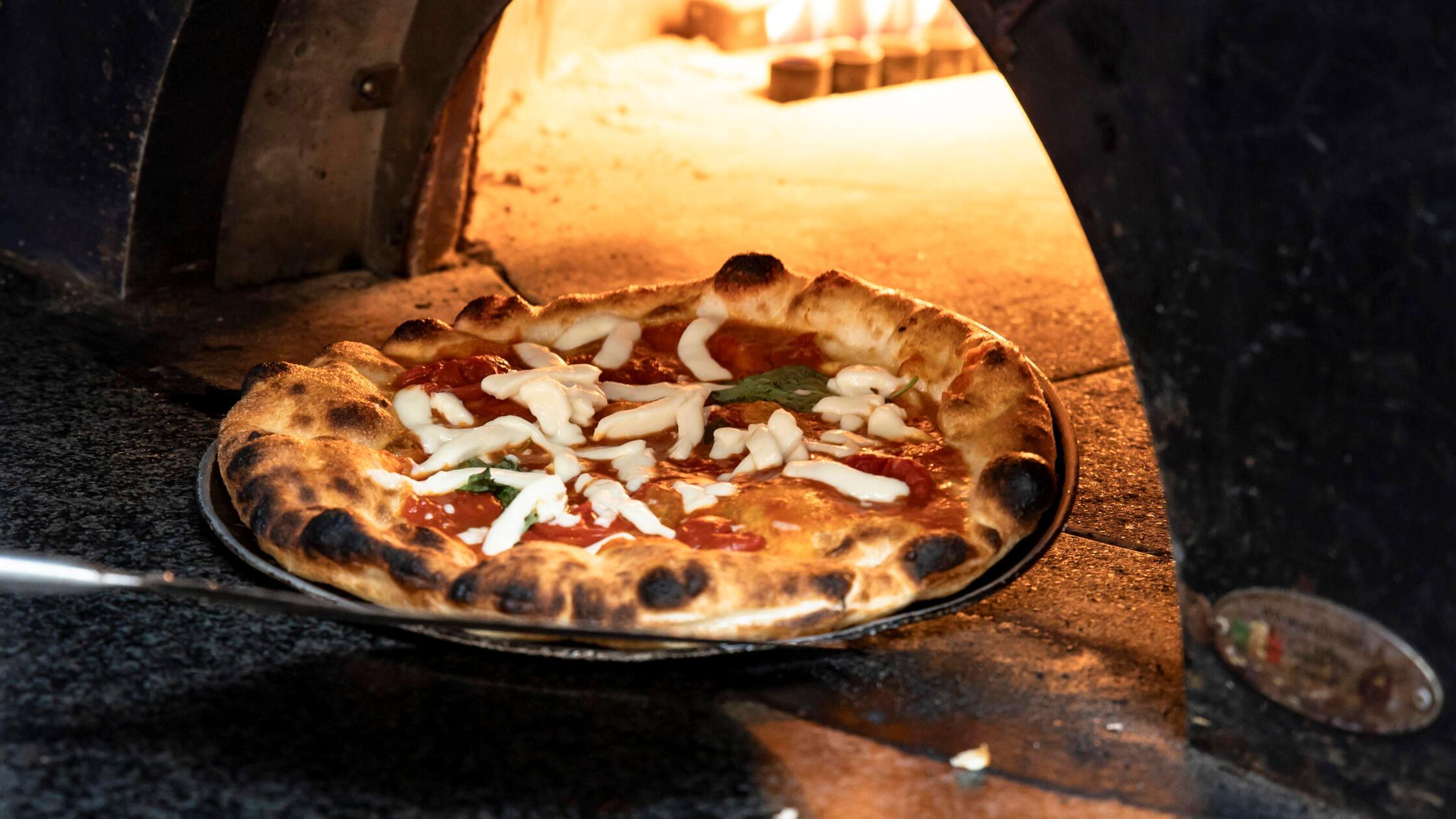 Eine neapolitanische Pizza kommt aus dem Ofen in B