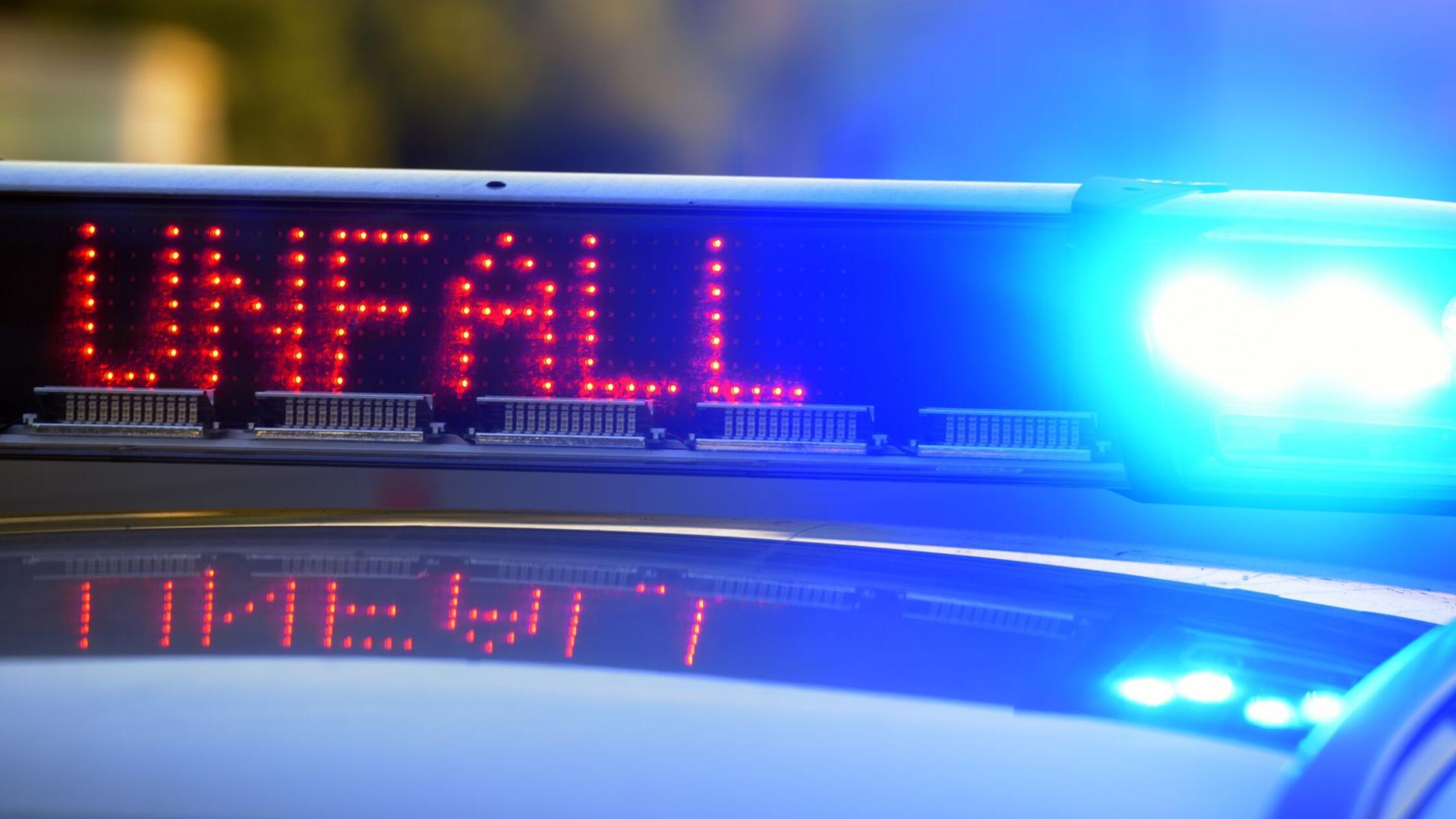 Auf einem Polizeifahrzeug warnt eine Leuchtschrift
