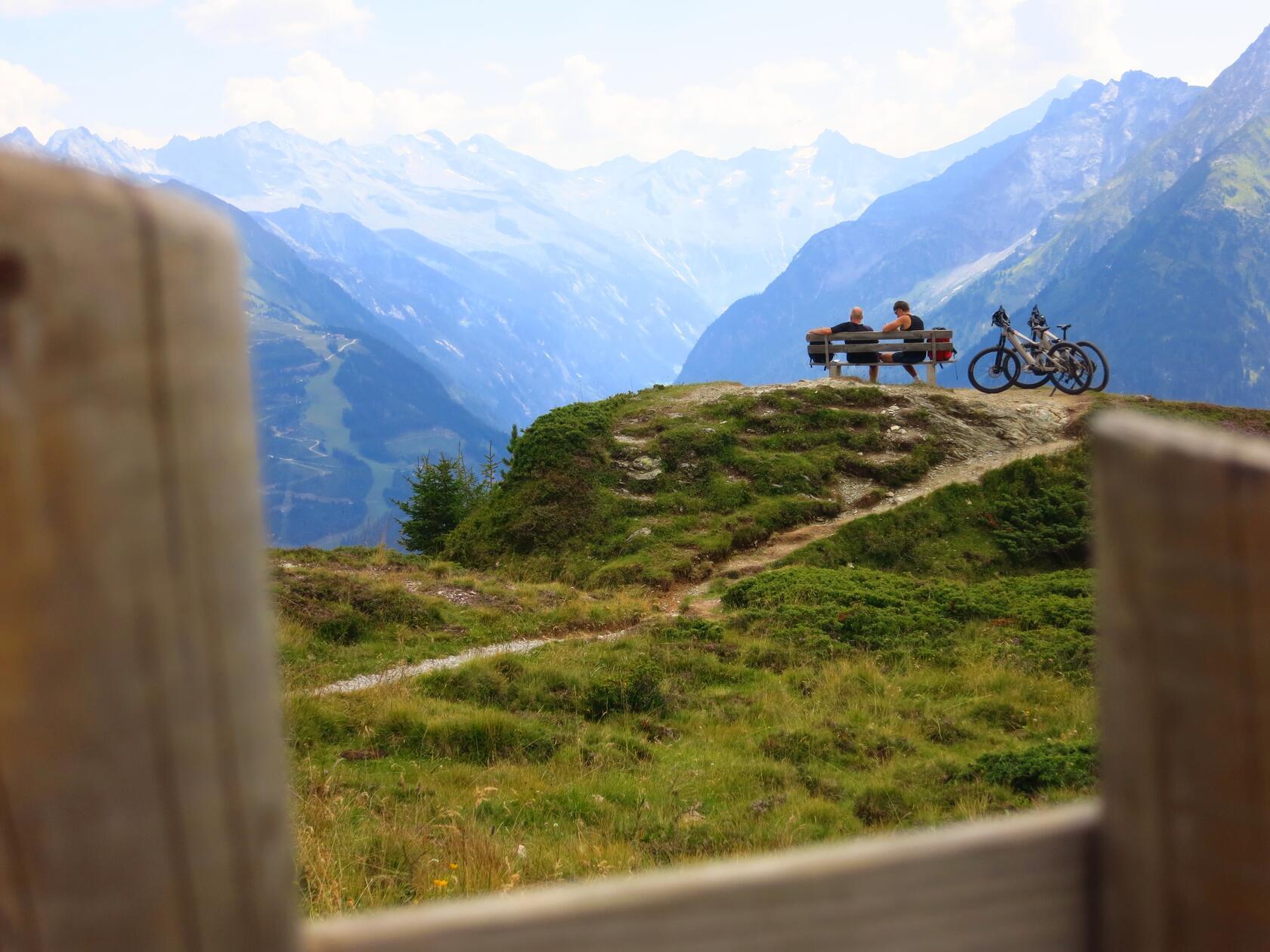Mountainbiker blicken in ein Nachbartal hinein.