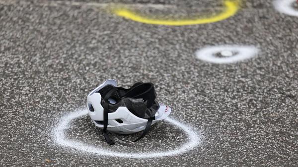 Ein zerstörter Fahrradhelm liegt auf der Straße an