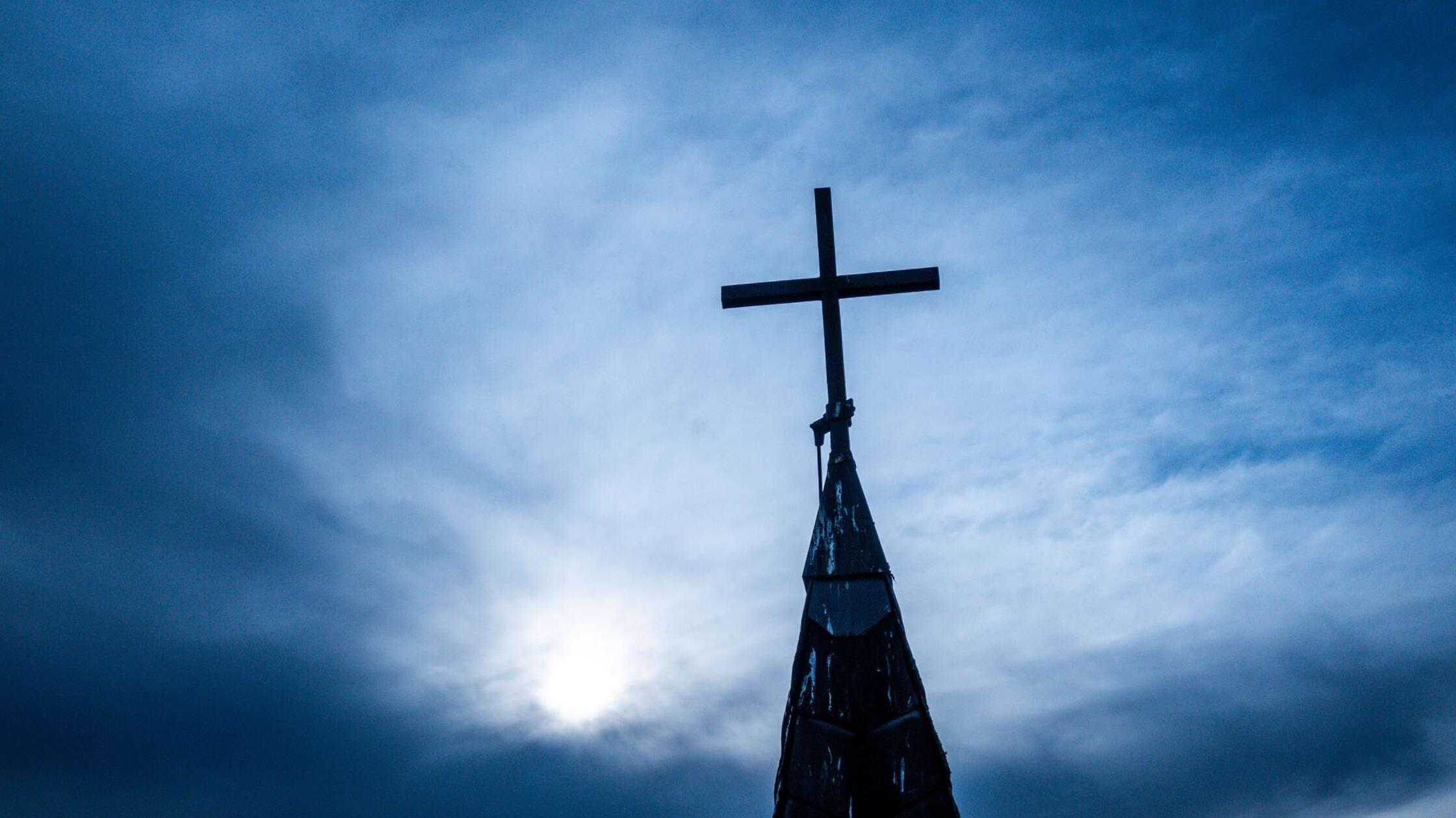 Ein Kirchenkreuz auf dem Dach der entwidmeten ehem