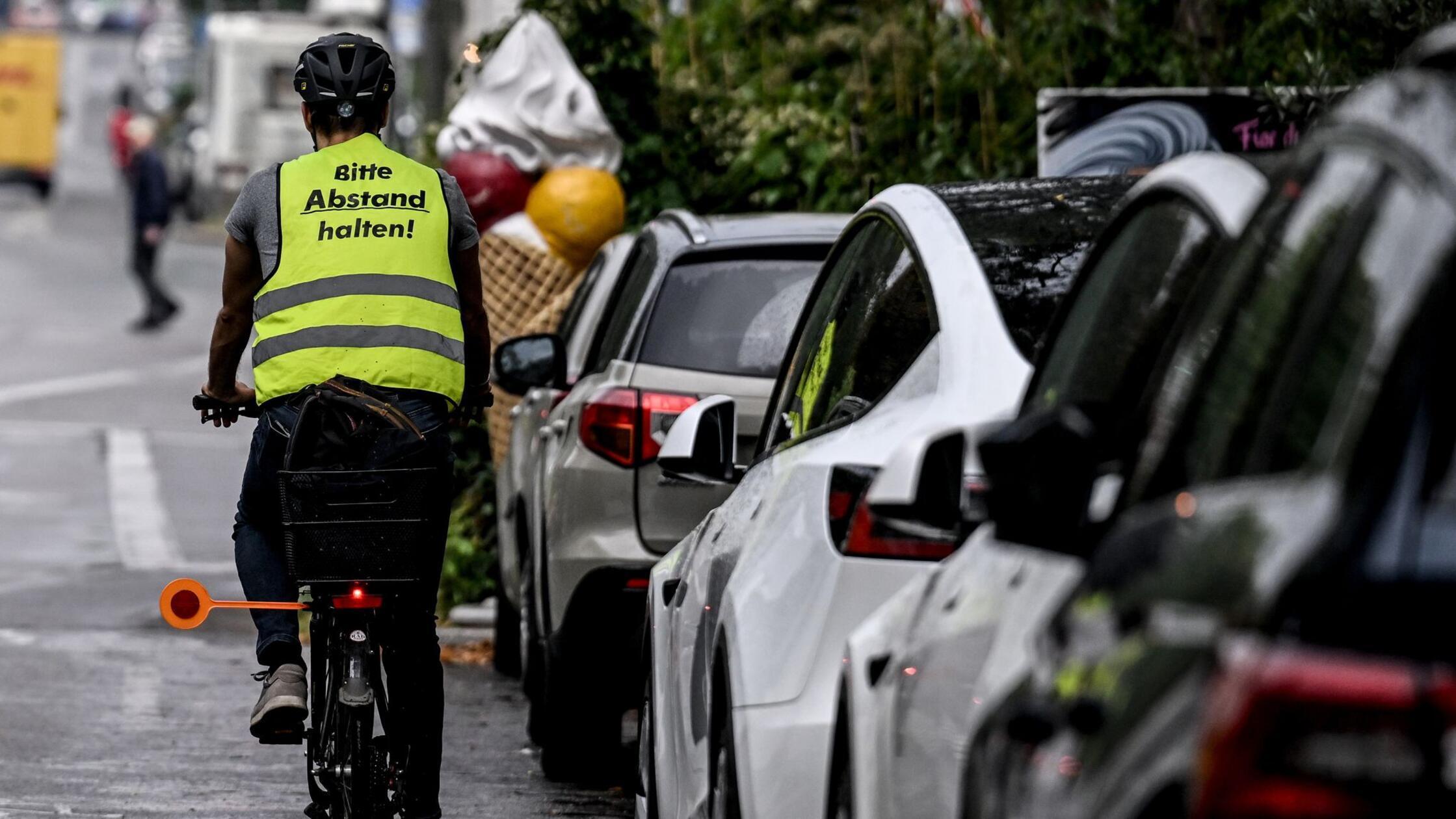 Ein Radfahrer fährt mit einer Weste mit der Aufsch