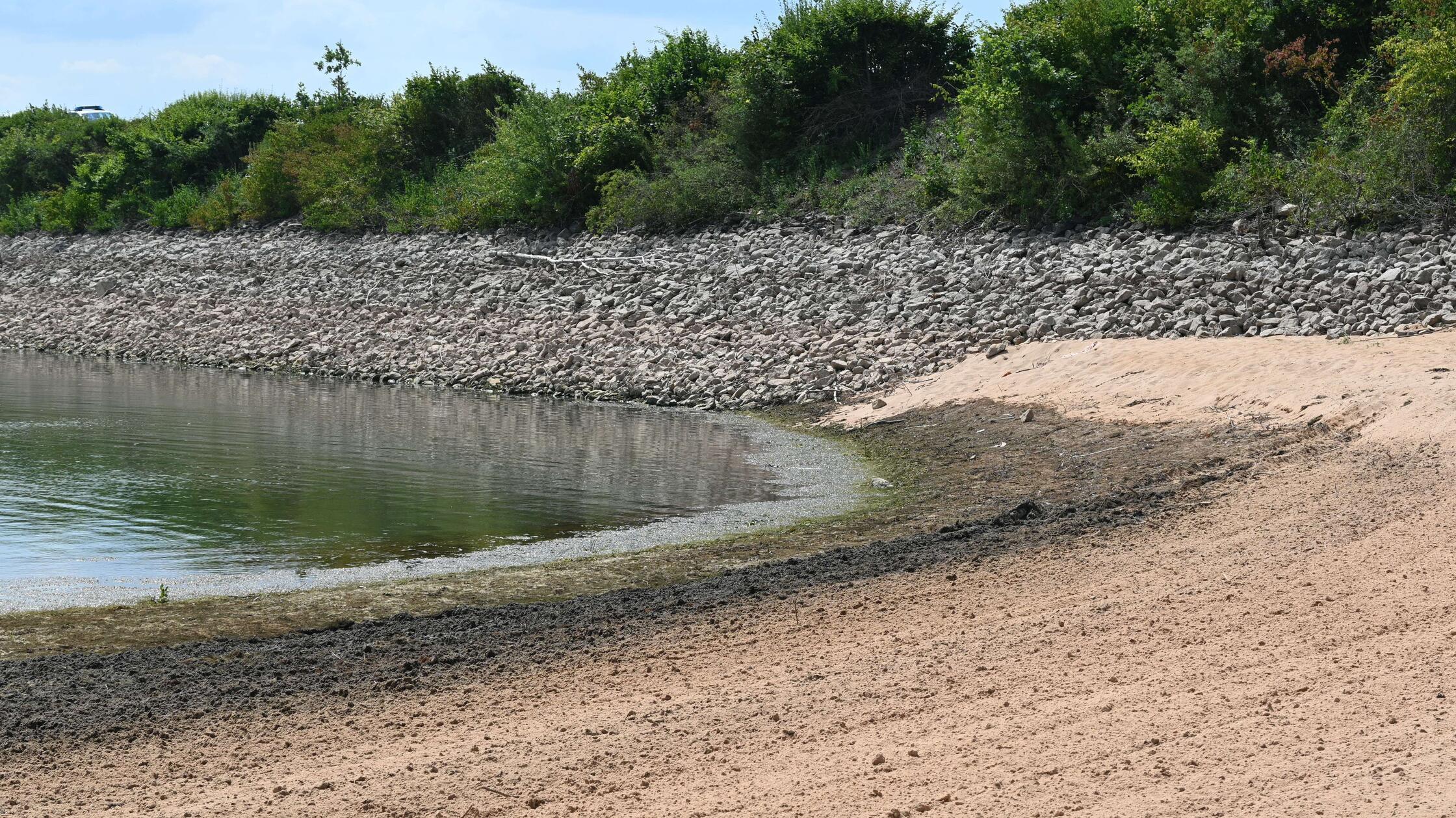 Im Hintergrund sieht man den Damm zwischen dem Kleinen und Großen Brombachsee. Der niedrige Wasserstand im Großen Brombachsee lässt sich auch hier gut ablesen: Zu den meisten Jahreszeiten sind die Steine hier nicht sichtbar.