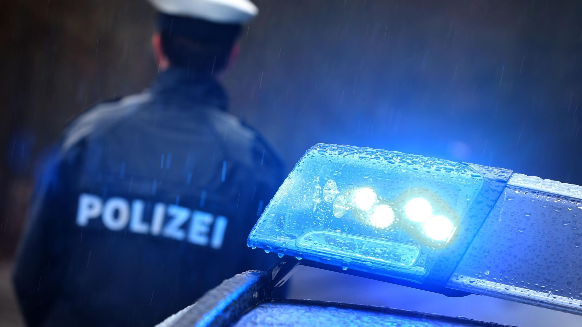ILLUSTRATION - Ein Polizist steht im Regen vor ein