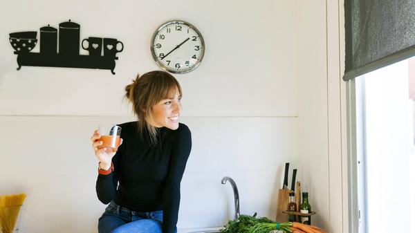 Young woman drinking fresh grapefruit juice in her