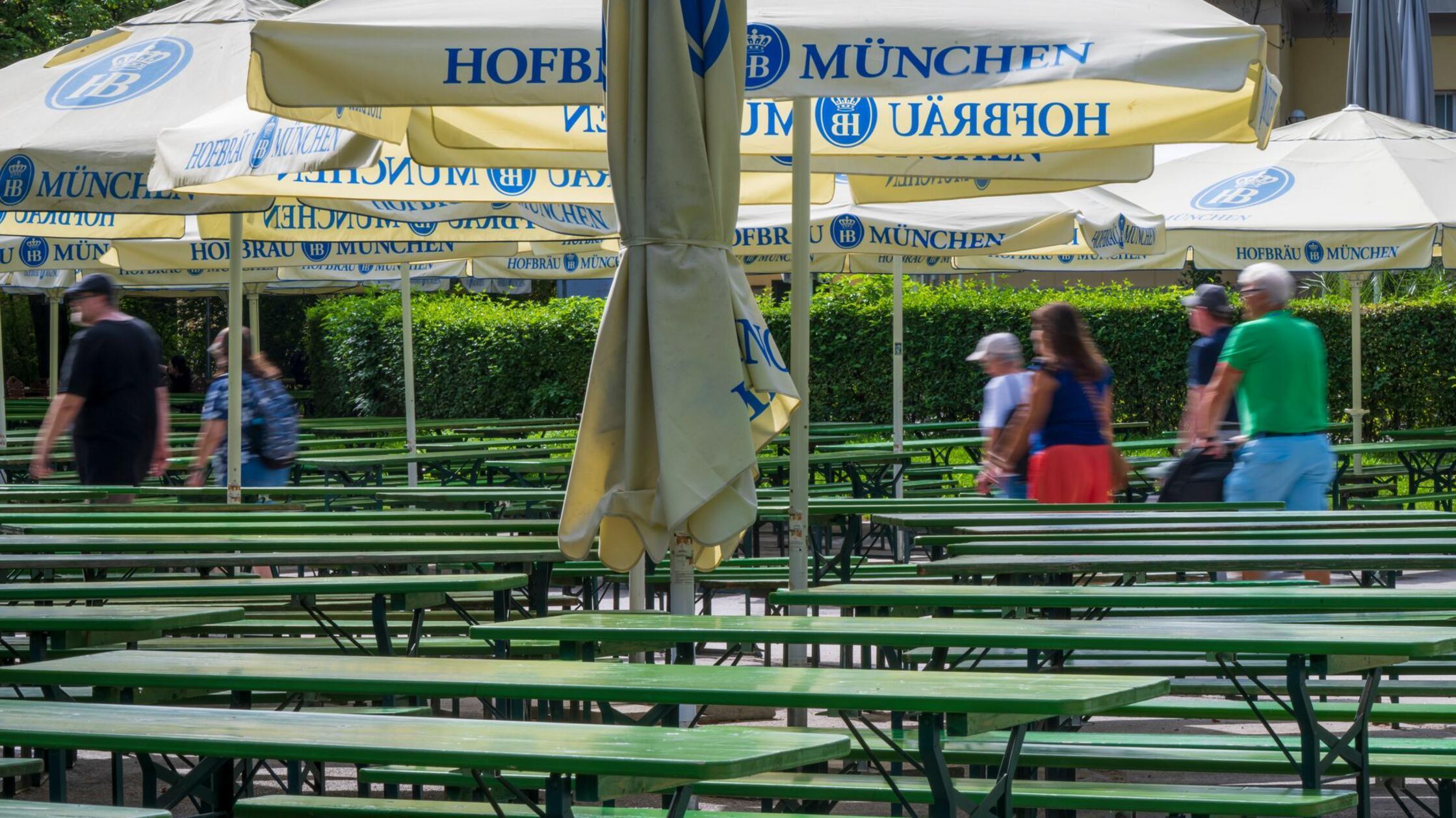 Spaziergänger laufen durch den noch leeren Biergar