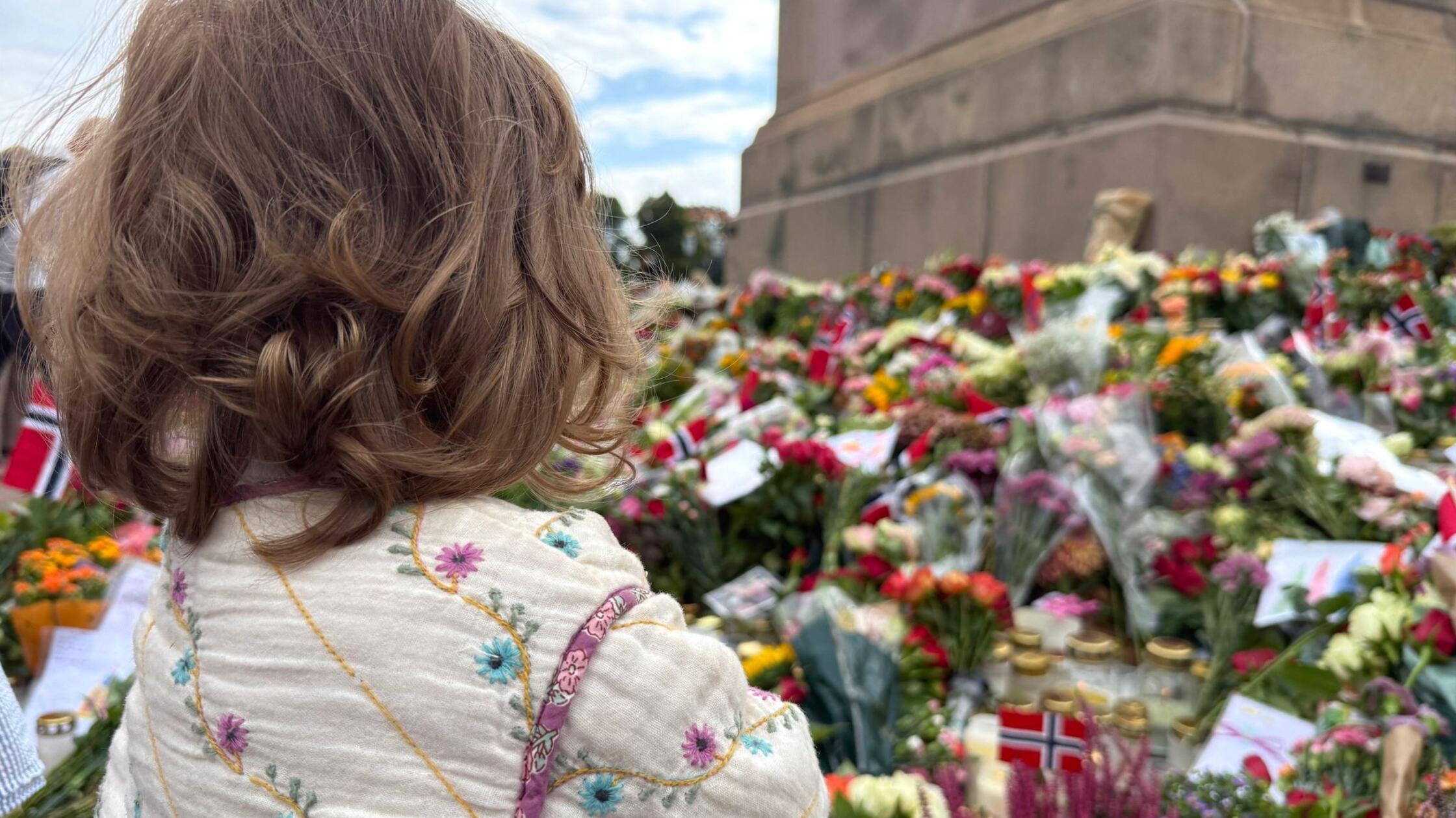 Die kleine Lara steht vor den vielen Blumen und Ke