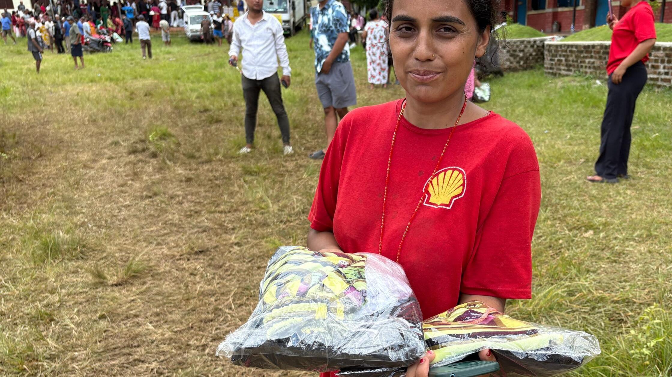 Die Nepalesin Samjhana Pokharel hält verpackte Kle