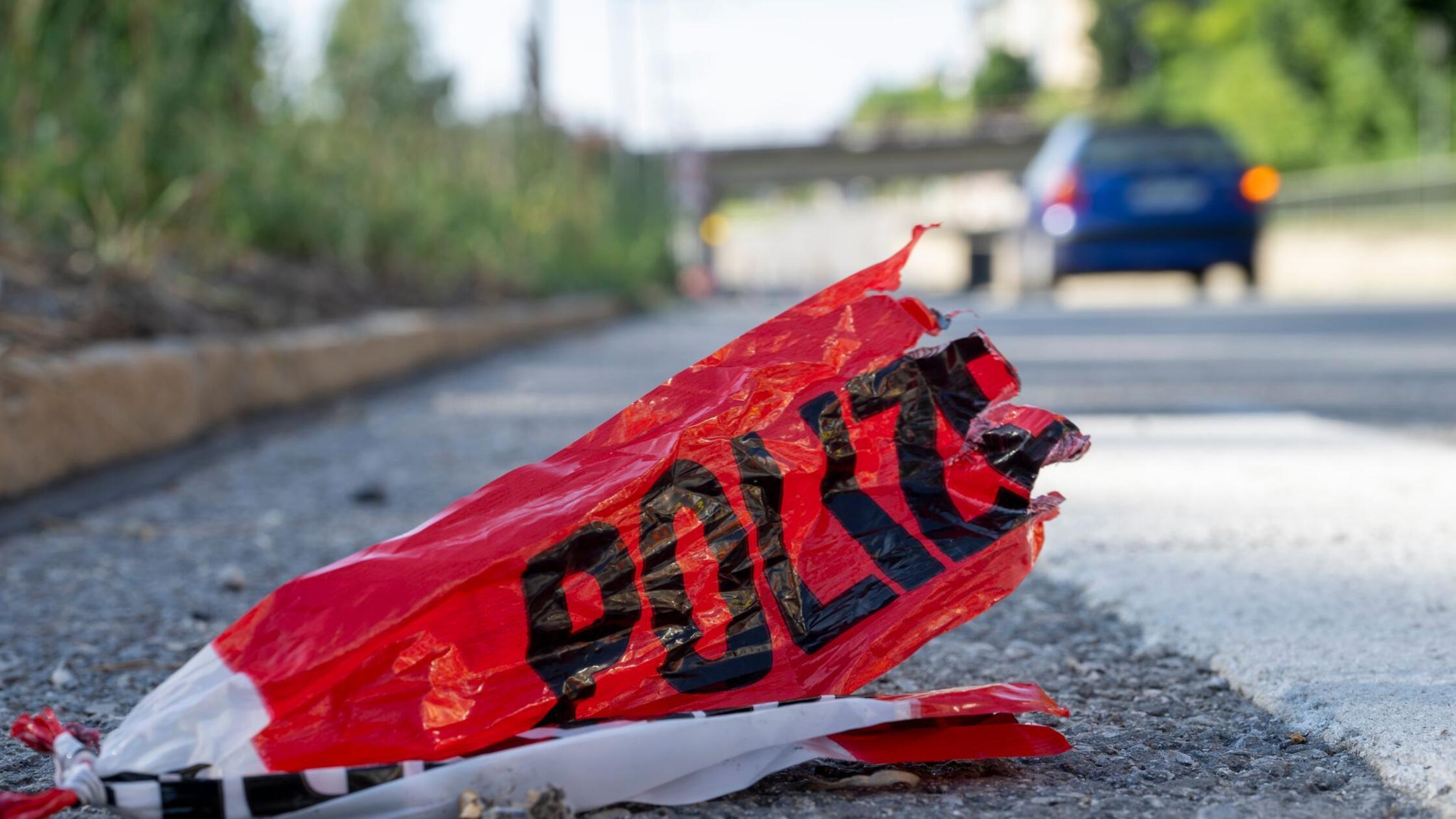 Reste eines Absperrbandes der Polizei liegen auf d