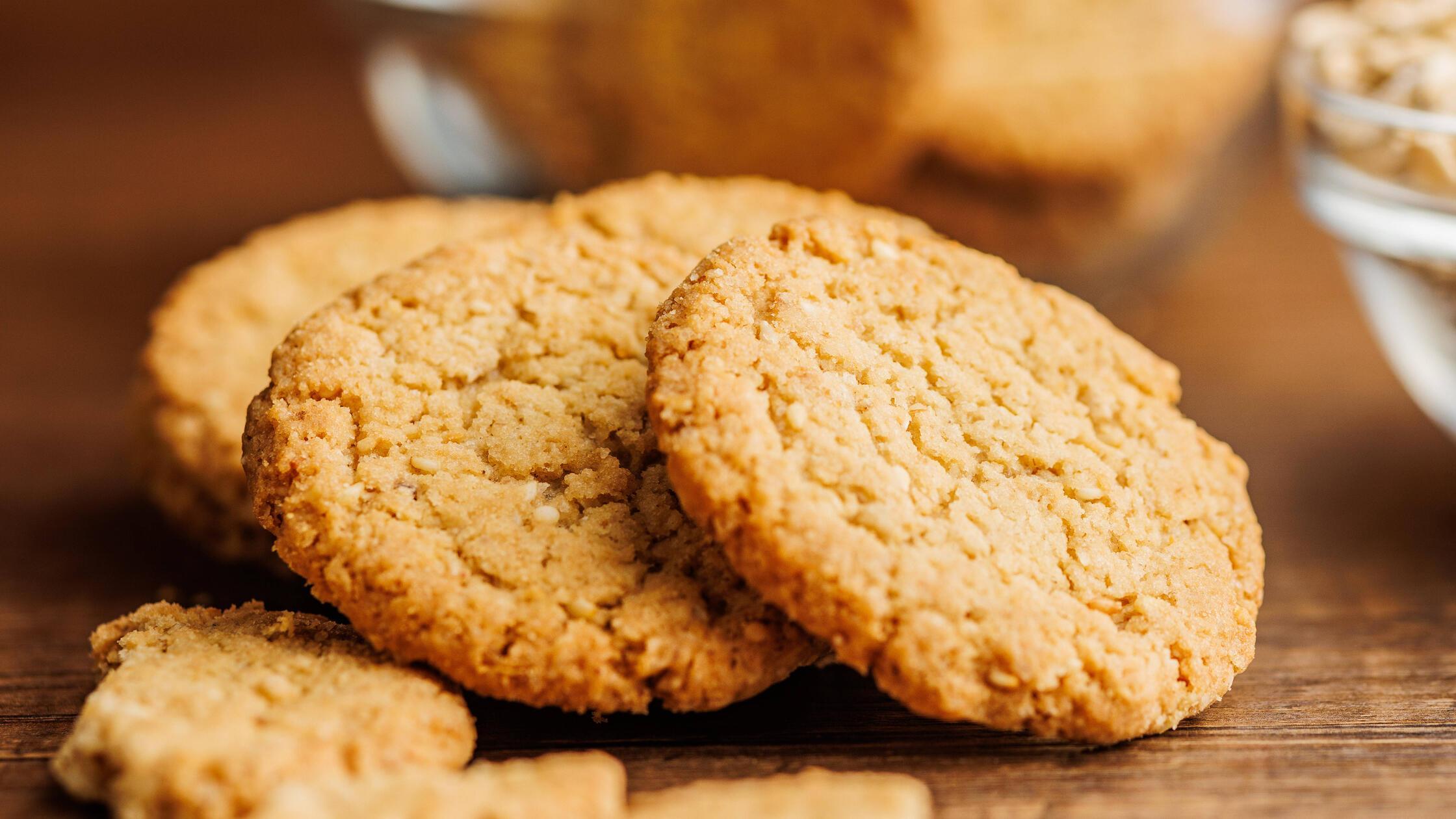 Tasty oatmeal cookies and rolled oat on wooden tab