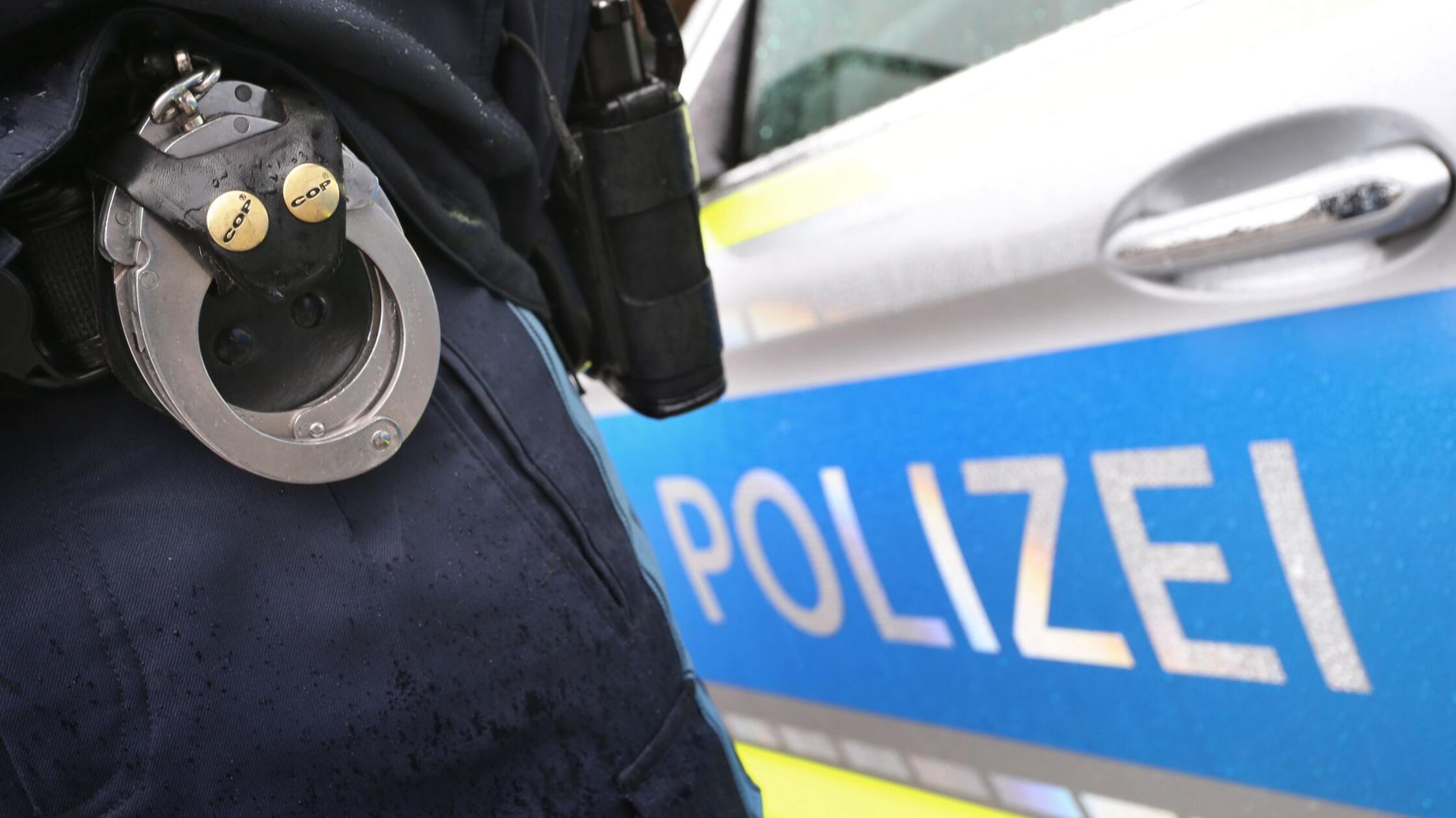 Ein Polizist mit Handschellen und einer Pistole am