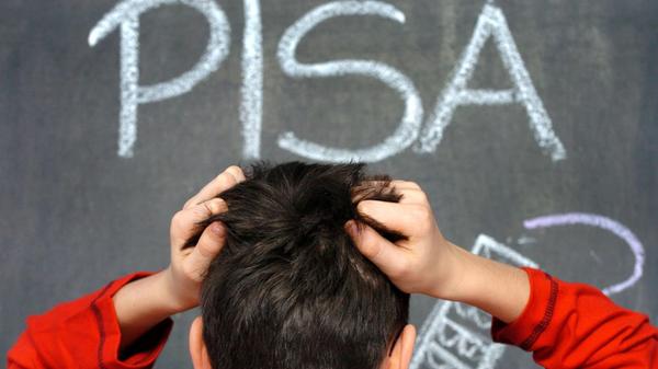 Ein Schüler rauft sich vor dem mit Kreide an eine