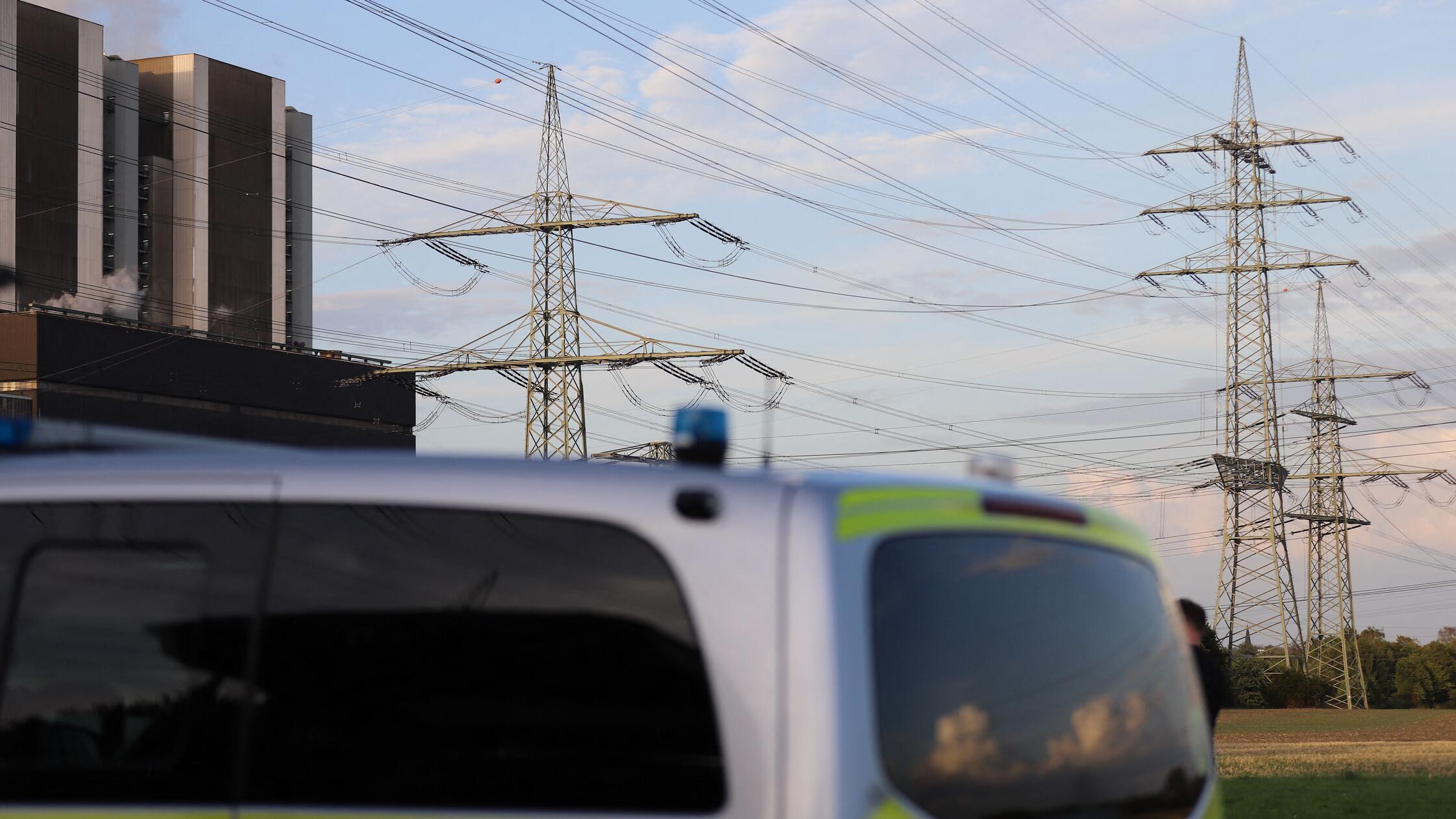 Ein Polizeifahrzeug steht vor Stromleitungen am Kr