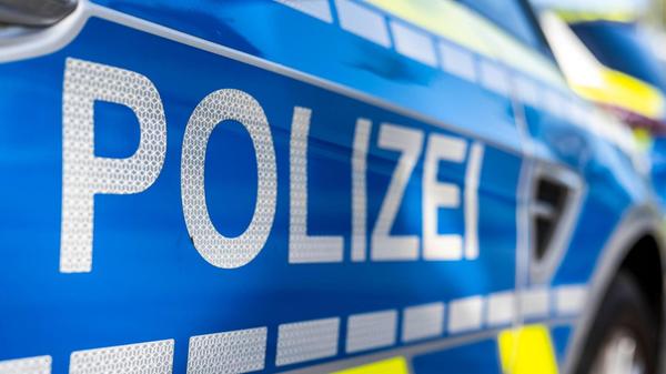 An der Tür von einem Streifenwagen steht der Schri