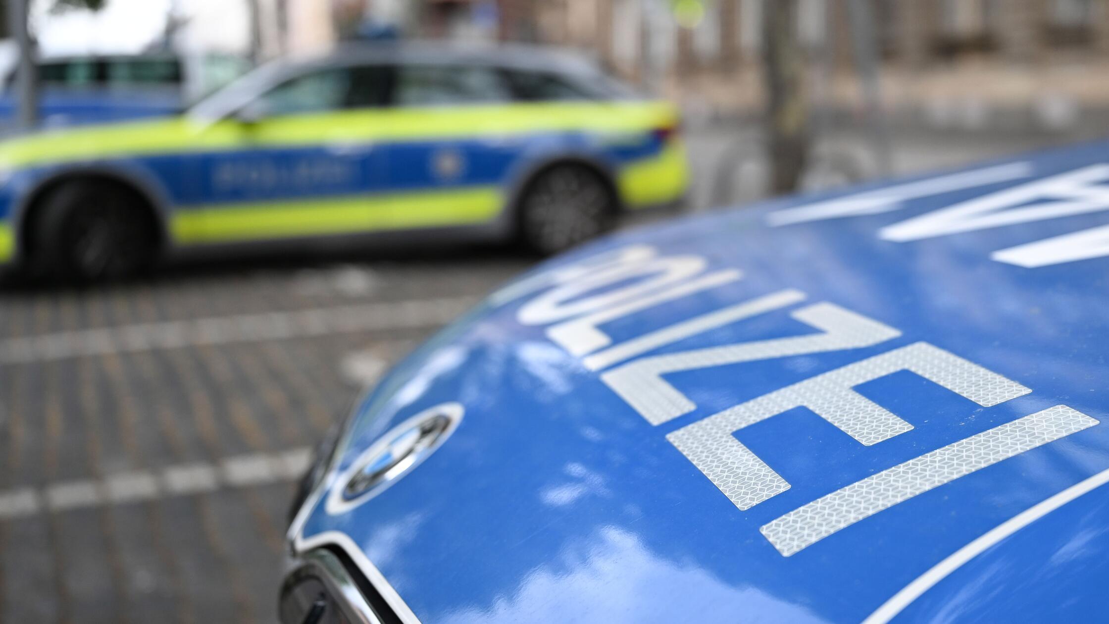 Polizeifahrzeuge stehen vor einer Polizeiwache. (z