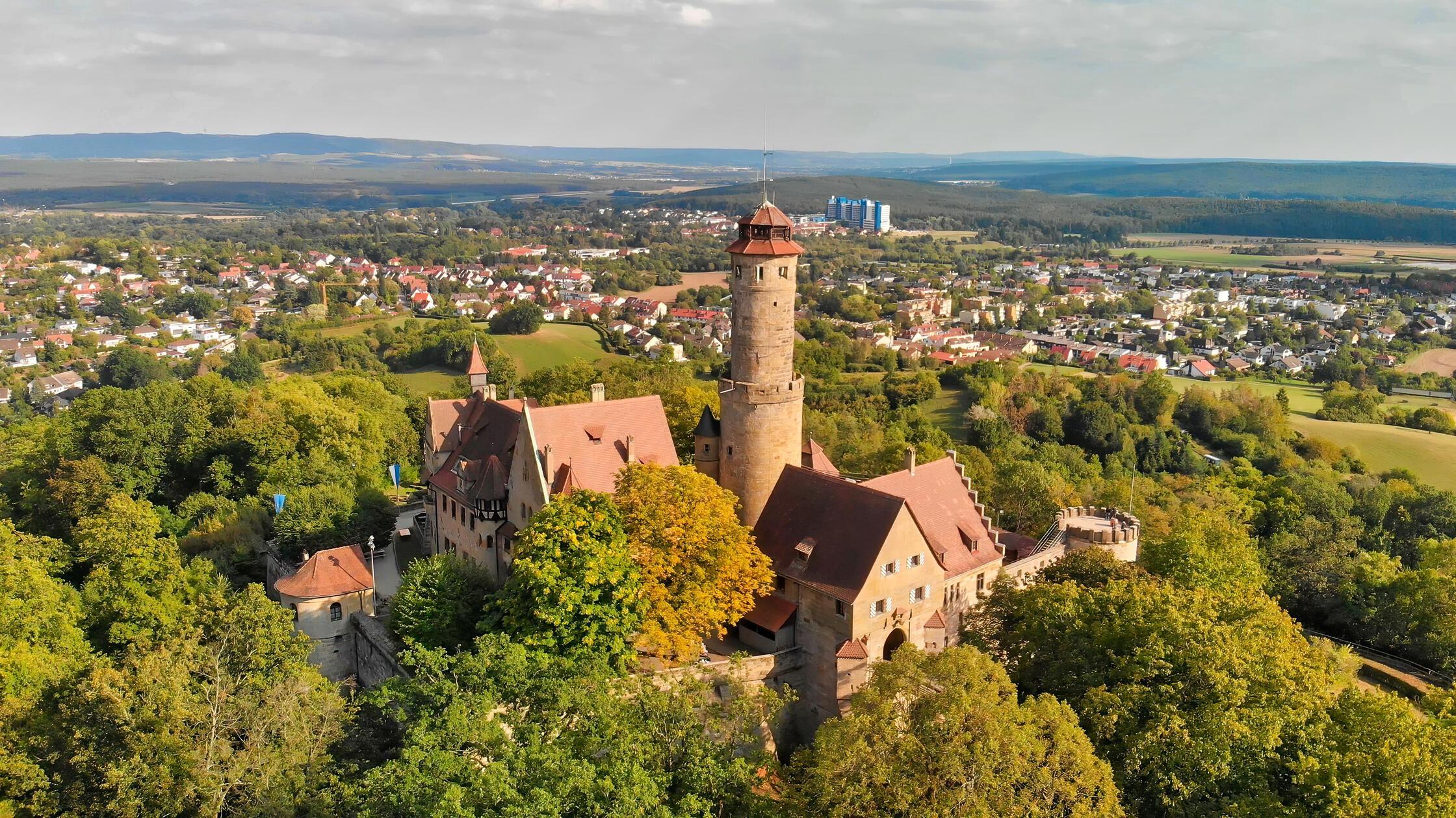 Wer Bamberg besucht, kommt an der <b>Altenburg</b> kaum vorbei: Die mittelalterliche Burganlage sitzt auf dem höchsten der sieben Bamberger Hügel und gehört zu den Wahrzeichen der Stadt. Erstmals 1109 erwähnt, diente sie vom 14. bis ins 16. Jahrhundert den Bamberger Fürstbischöfen als Residenz und Zufluchtsort. Im Zweiten Markgrafenkrieg wurde die Anlage 1553 weitgehend zerstört. Erhalten blieben unter anderem der markante Bergfried und Teile der Ringmauer.
Im 19. Jahrhundert erhielt die Altenburg ihr romantisches Erscheinungsbild. Heute führen mehrere Wege durch den Altenburger Wald hinauf zur Burg.