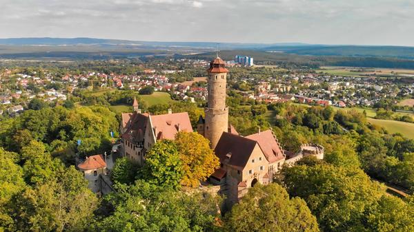 Wer Bamberg besucht, kommt an der <b>Altenburg</b> kaum vorbei: Die mittelalterliche Burganlage sitzt auf dem höchsten der sieben Bamberger Hügel und gehört zu den Wahrzeichen der Stadt. Erstmals 1109 erwähnt, diente sie vom 14. bis ins 16. Jahrhundert den Bamberger Fürstbischöfen als Residenz und Zufluchtsort. Im Zweiten Markgrafenkrieg wurde die Anlage 1553 weitgehend zerstört. Erhalten blieben unter anderem der markante Bergfried und Teile der Ringmauer.
Im 19. Jahrhundert erhielt die Altenburg ihr romantisches Erscheinungsbild. Heute führen mehrere Wege durch den Altenburger Wald hinauf zur Burg.