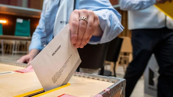 Eine Wählerin wirft in einem Wahllokal im Rathaus