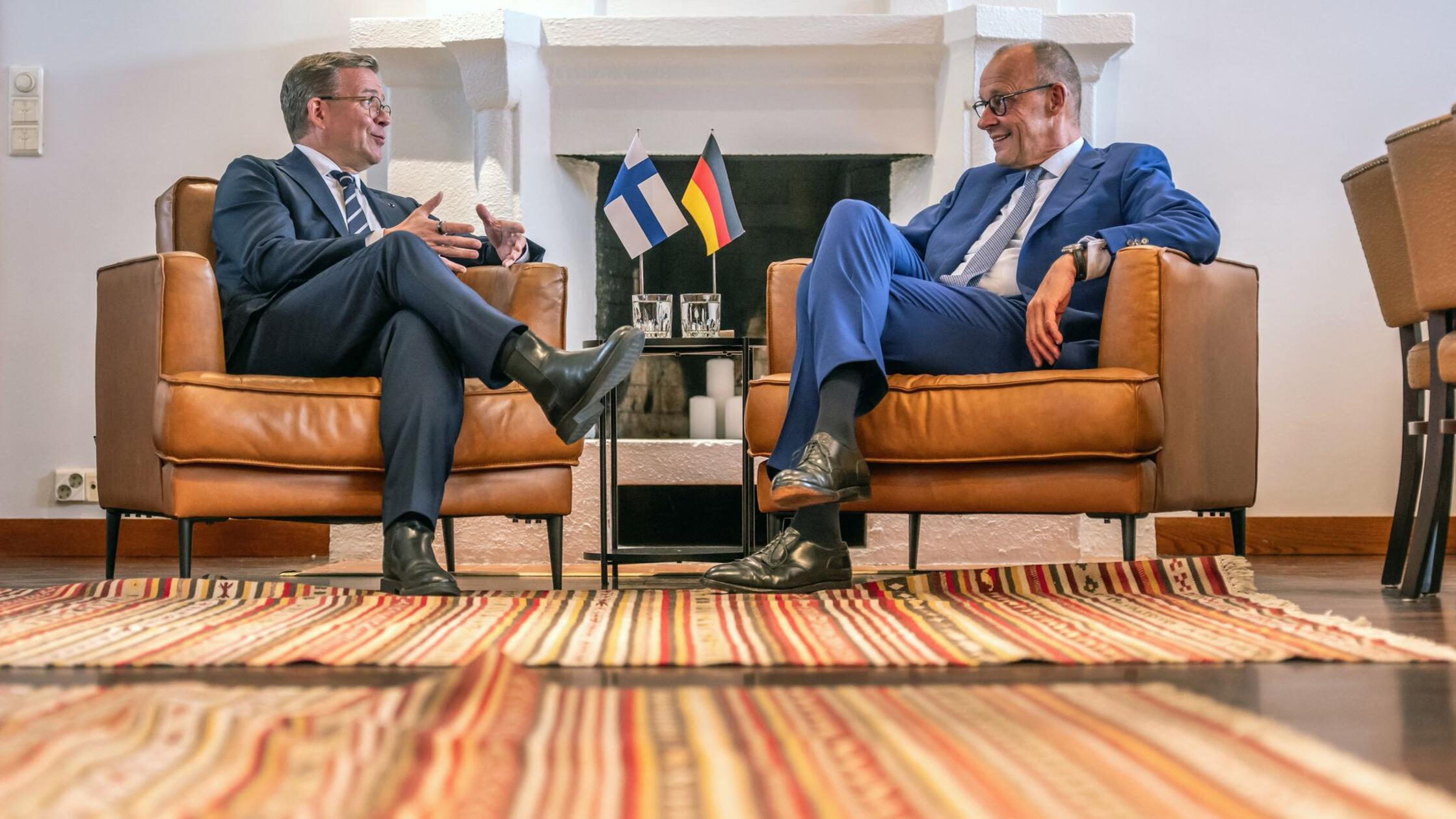 Bundeskanzler Friedrich Merz (CDU) sitzt neben Pet