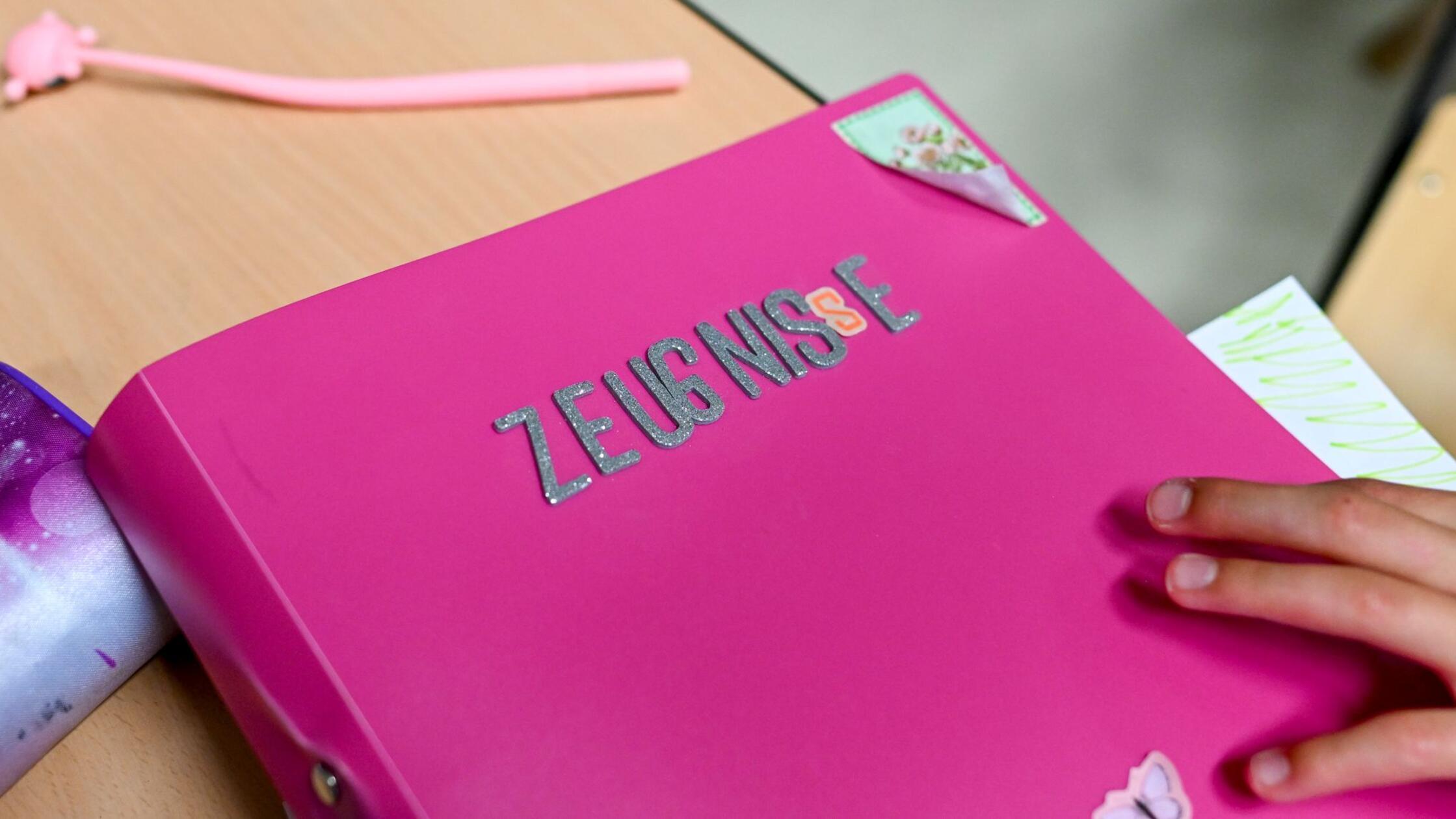 Eine Schülerin legt ihr Zeugnis am letzten Schulta