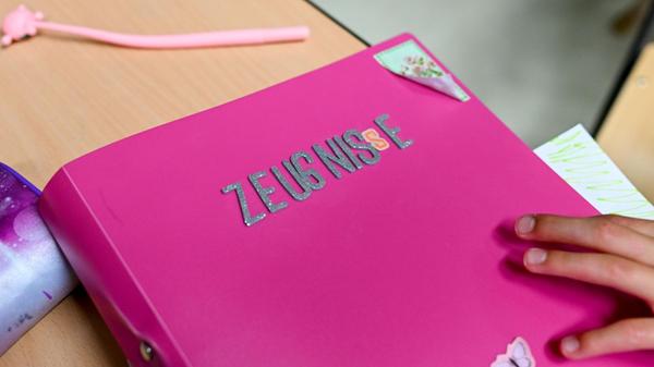 Eine Schülerin legt ihr Zeugnis am letzten Schulta