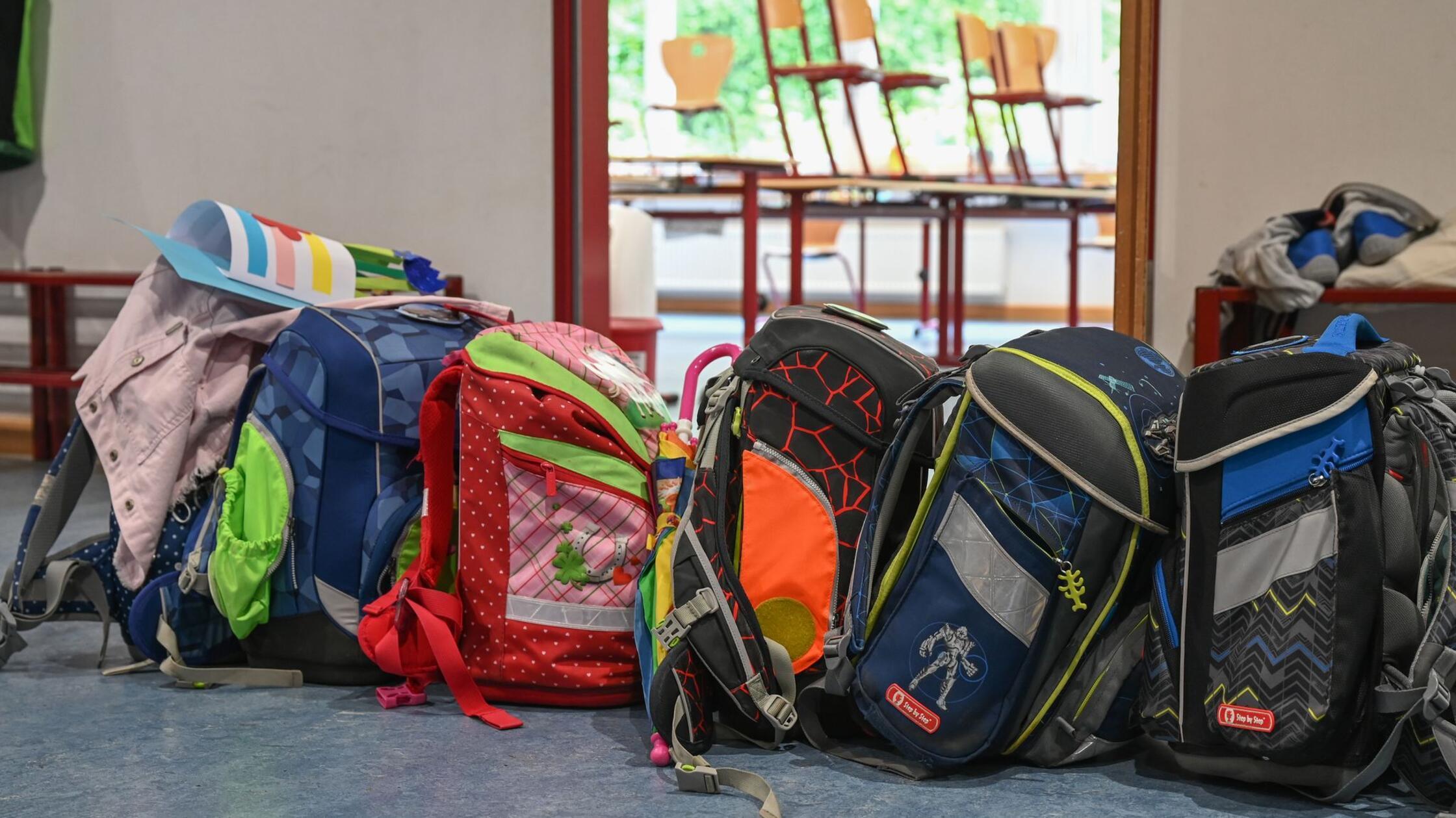 Schulranzen stehen vor einem Klassenzimmer. (zu dp