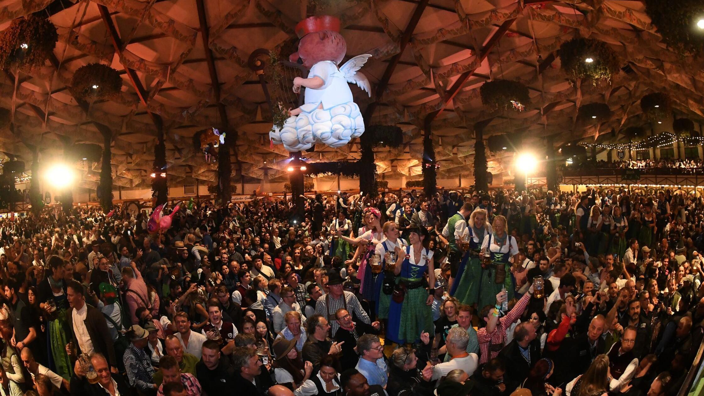 Bedienungen stehen auf den Tischen im Hofbräuzelt 