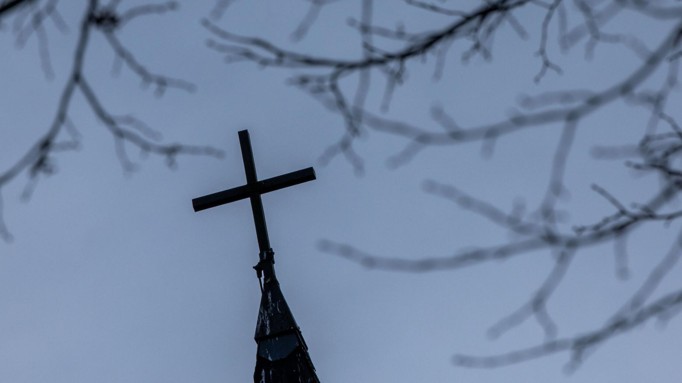 Ein Kirchenkreuz auf dem Dach der entwidmeten ehem