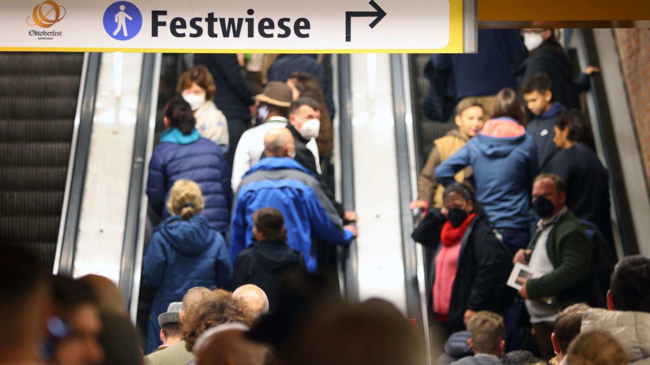 Menschen verlassen auf einer Rolltreppe eine U-Bah