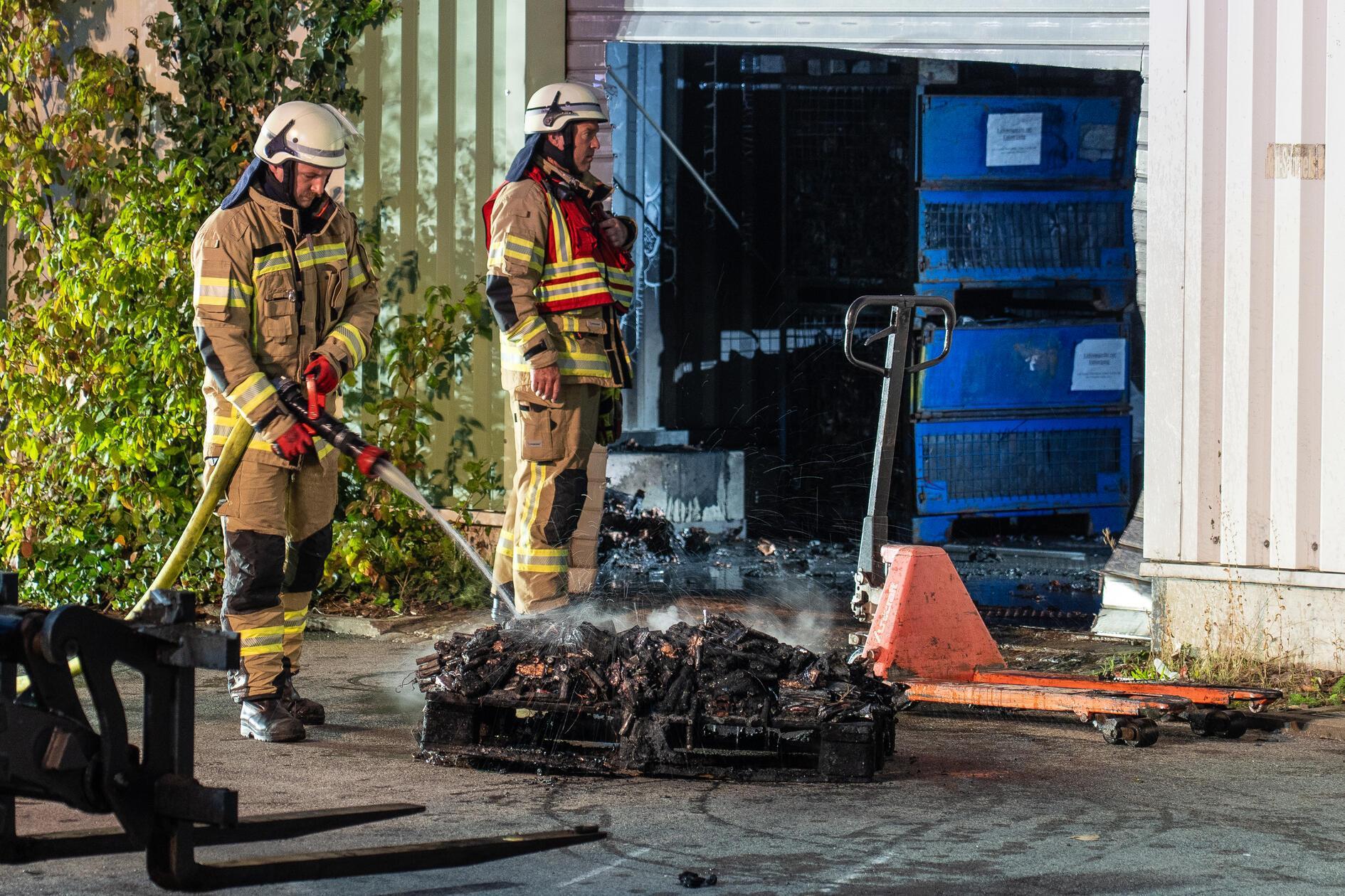 Die Einsatzkräfte der Feuerwehr verschafften sich gewaltsam Zugang zu der vollständig verrauchten Halle und löschten die brennenden Akkus ab. Die Löscharbeiten gestalteten sich dabei schwierig.