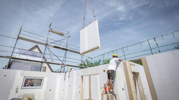 Ein Bauarbeiter steht auf einer Leiter und arbeite