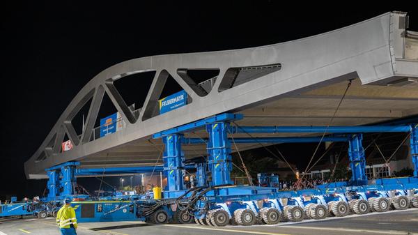 Zum Einsatz kommt ein sogenannter SPMT – ein Self-Propelled Modular Transporter. Dabei handelt es sich um ein selbstfahrendes, computergesteuertes Schwerlast-Modulfahrzeug mit insgesamt 1180 PS, wie News5 berichtet.