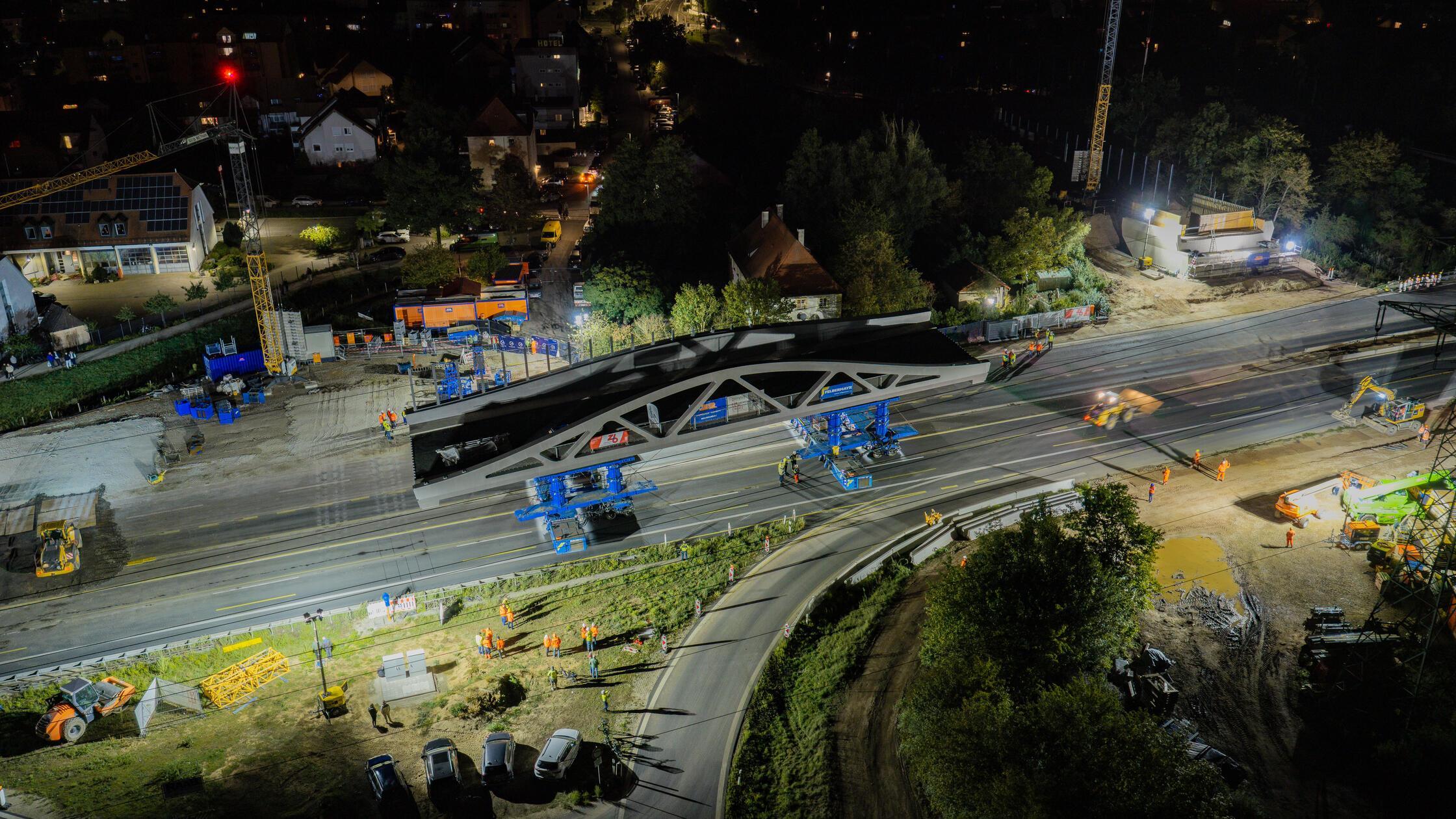 Für den Brückeneinschub fahren die Schwerlastmodule unter die vorbereitete Konstruktion, heben diese an und bewegen die 1300 Tonnen schwere Brücke anschließend über die Autobahn bis zu den vorbereiteten Widerlagern. 