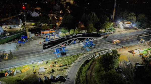 Für den Brückeneinschub fahren die Schwerlastmodule unter die vorbereitete Konstruktion, heben diese an und bewegen die 1300 Tonnen schwere Brücke anschließend über die Autobahn bis zu den vorbereiteten Widerlagern.
